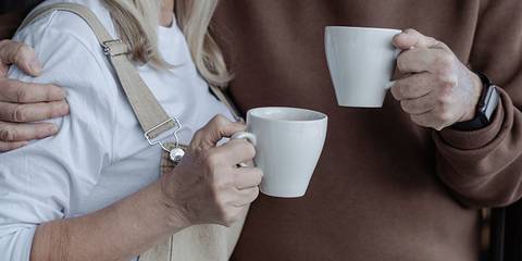Mann und Frau halten Kaffeetassen in den Händen